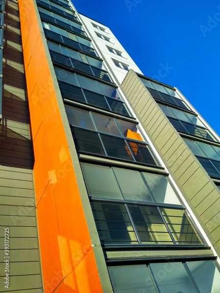 Fototapeta Corner of a multi-storey building against the sky with balconies.
