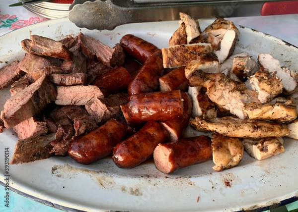 Obraz A mixed grill platter of meats includes sausages, chicken and steak.