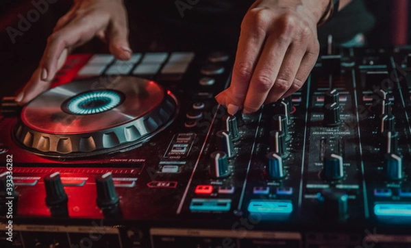 Fototapeta DJ Hands creating and regulating music on dj console mixer in concert nightclub stage