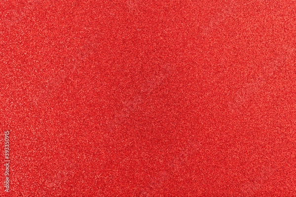 Fototapeta Shiny surface. Red glitter texture. Christmas abstract background, defocused