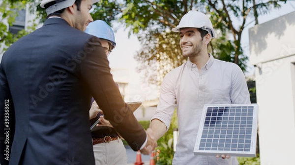 Fototapeta Electrical Engineer Technician Talk to business people to invest in install solar cells outside building or industrial factory. Collaboration on energy reduce for environment. Concept key worker