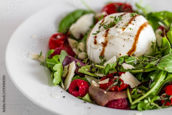 Fototapeta Salad with Italian burrata cheese, arugula, cherry tomatoes, parmesan and raspberry with balsamic glaze