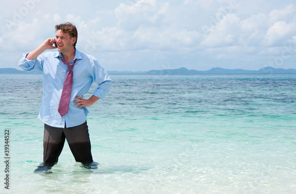 Fototapeta Business man calling by cell phone on the beach