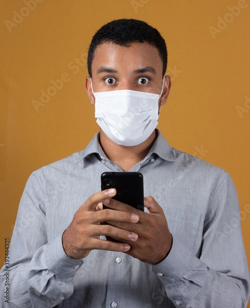 Fototapeta scared man with wearing a mask with a cellphone