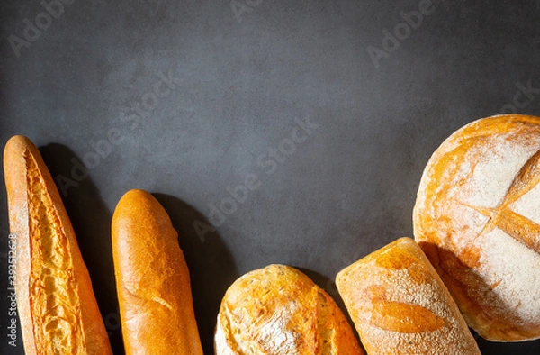 Fototapeta Different types of loaves of artisan bread close-up with copy space space for text