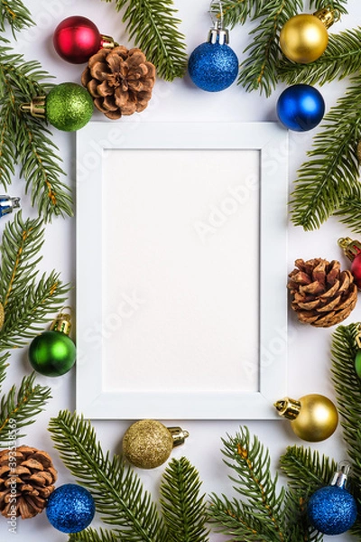 Fototapeta Christmas composition with empty picture frame. Colorful ball ornament, pine cones and fir needles decorations. Mock up greetings card template