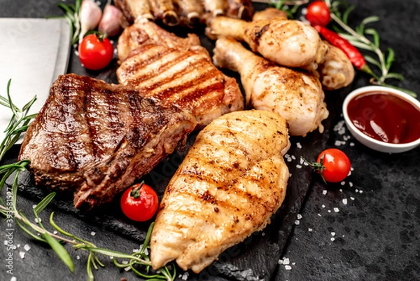 Fototapeta Various types of grilled meat, beef, pork, chicken on stone background	