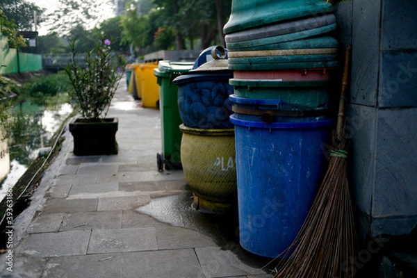 Fototapeta Row of garbage bins lined up along the park