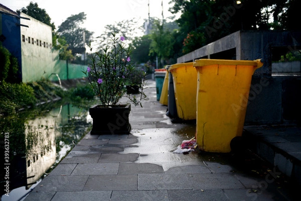 Fototapeta Row of garbage bins lined up along the park