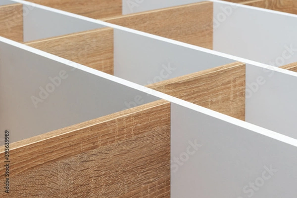 Fototapeta Empty wooden shelving unit with white partitions, background texture