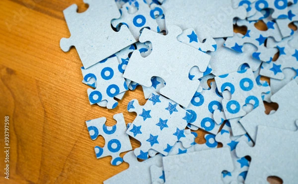 Fototapeta Close-up blue puzzles of different sizes lying on a wooden surface