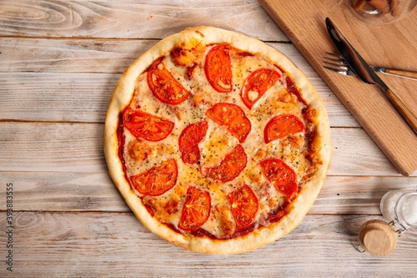 Fototapeta Margherita pizza with tomatoes on the wooden table