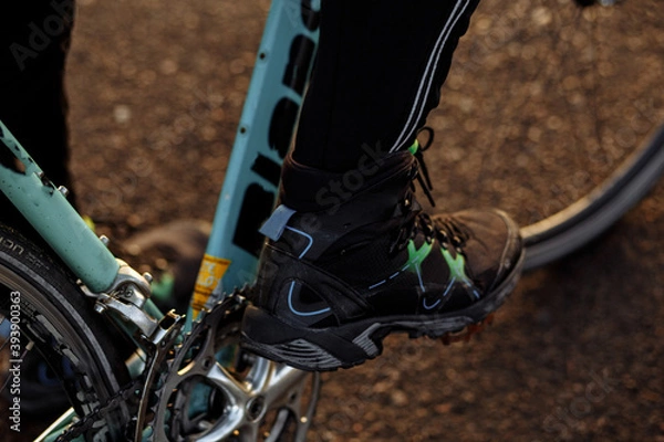 Fototapeta man on a blue bicycle in the morning cold season goes to work