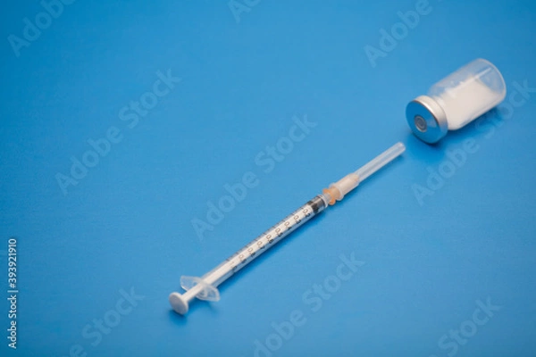 Obraz syringe with vaccine bottle, blue background