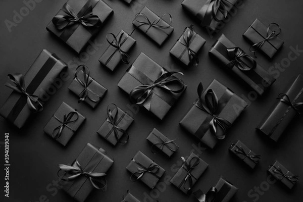 Fototapeta Elegant black Christmas theme. Wrapped gifts in black matte paper with ribbon