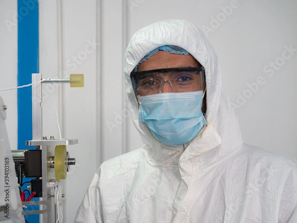 Fototapeta Portrait of engineer worker in protective suits, masks, and gloves in the manufacture of surgical masks for coronavirus..