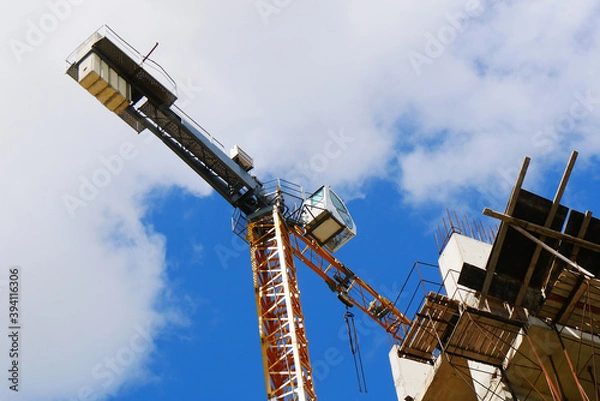 Obraz Сrane near building. Concrete building under construction. Industrial background.