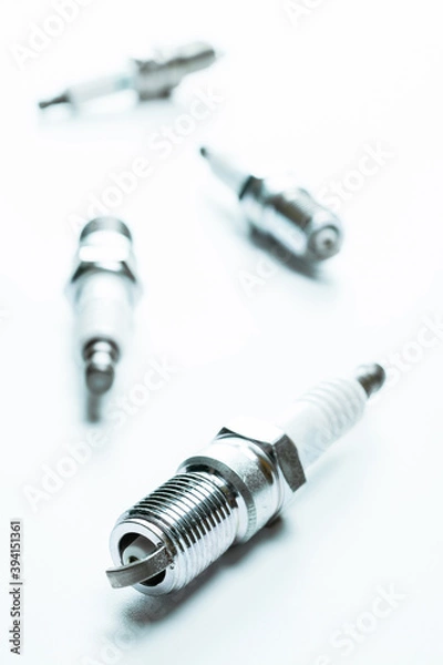 Fototapeta Car engine. Set of new metal car part. Auto spark plugs or automotive piece isolated on white background. Automobile engine service.
