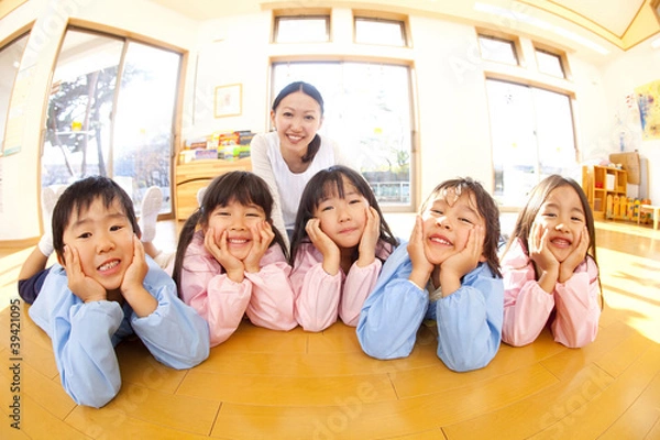Obraz 頬杖をついて微笑む幼稚園児と笑顔の幼稚園教諭