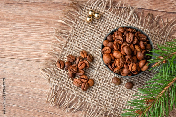 Fototapeta Grains of coffee and a branch of a christmas tree on a wooden table