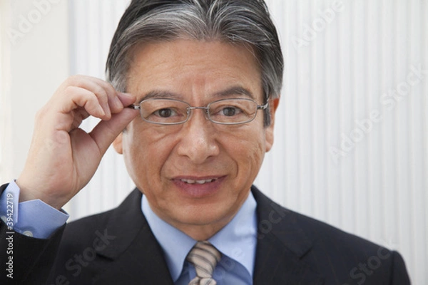 Obraz 眼鏡のフレームを掴むビジネスマン