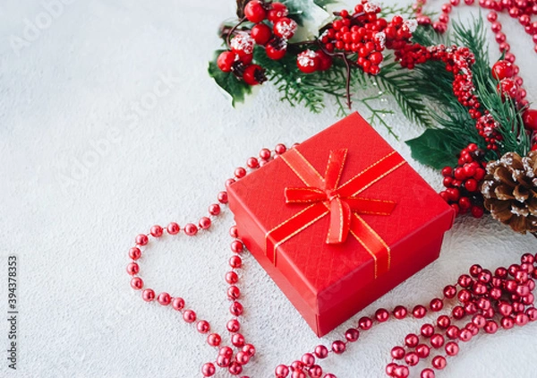 Fototapeta Red gift box, fir branches and christmas decor on a white background with copy space