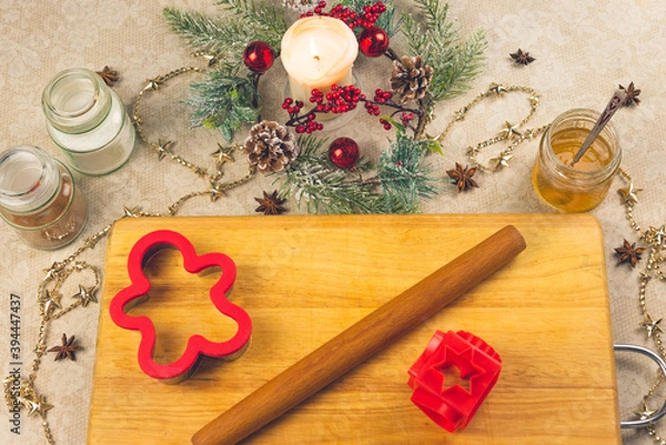 Obraz Traditional Christmas ginger cookies. Step-by-step recipe. Jars of spices, a baking dish, a Board and a candle with Christmas decor. The view from the top. Horizontal cropping. Selective focus