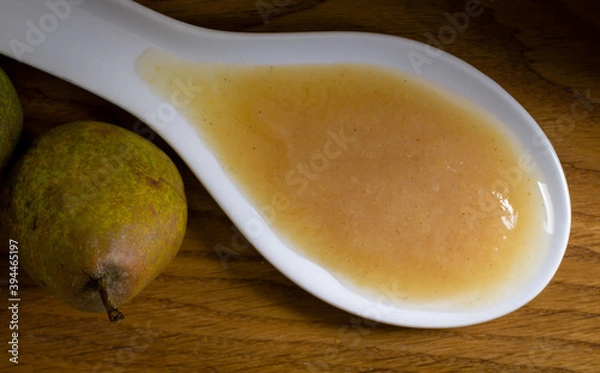 Fototapeta Birnenmus auf einem weißen Löffel mit Birne