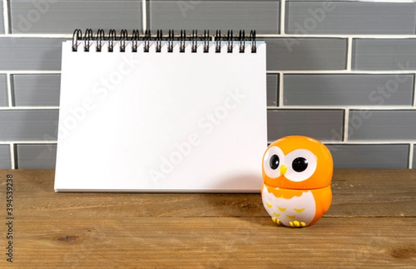 Fototapeta Blank note pad with black spiral and orange owl egg timer