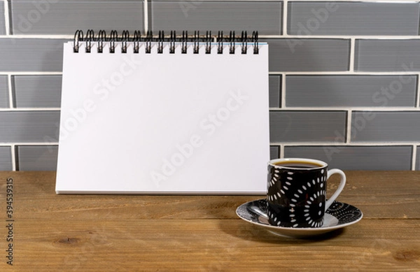 Fototapeta Blank spiral notepad in a modern kitchen with espresso
