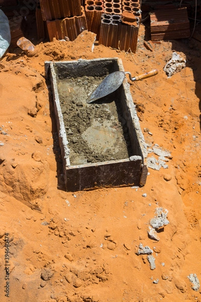 Fototapeta Elements for construction. Cement box and mason bucket. Eight hole ceramic bricks. Work under construction.