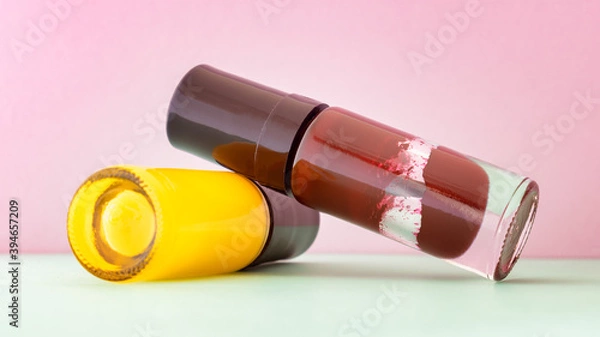Fototapeta Different colors of aged and broken nail polish in selective focus. Old and dry nail varnish without labels. Hardened and dried finger nail polish bottles. PAO code and expired cosmetics concept.