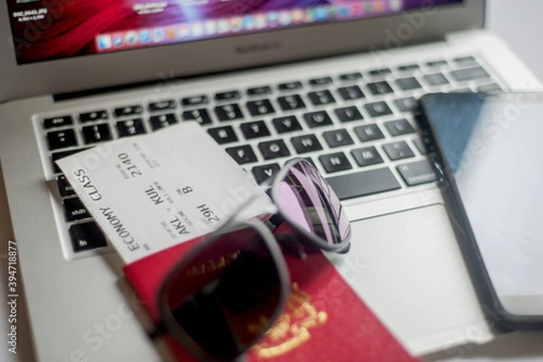 Fototapeta Planning a trip. Passport, Smartphone, Sunglass, Printed Boarding Pass and Laptop.
Top view.
Selective focus.