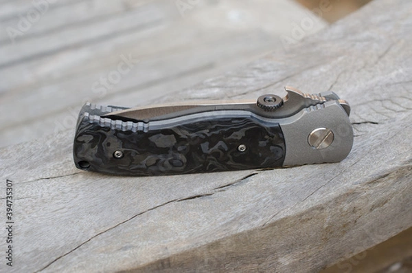 Fototapeta Titanium framelock folder knife with black mable carbonfiber scale.