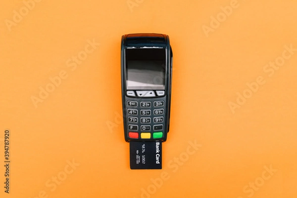 Fototapeta The bank card is inserted into the POS payment terminal. Electronic device for receiving payments. The process of paying for goods, conducting a transaction