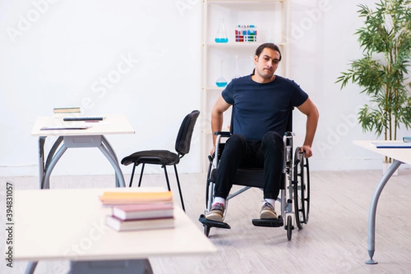 Fototapeta Young male student in wheel-chair preparing for exams