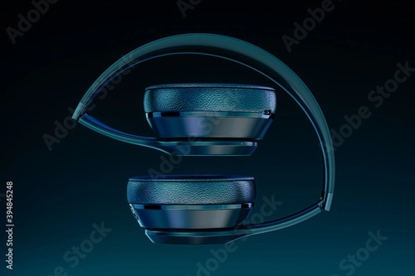Fototapeta headphones on blue. Looking Directly At Folded Generic Music Headphones, Floating, Falling, Suspended, Isolated In A Blue and Black Studio Background. 3d rendering.