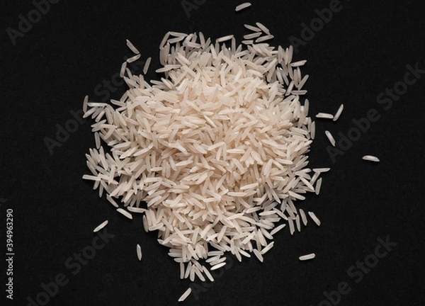 Fototapeta Heap of white basmati rice on black background.  Food design. Flat lay.