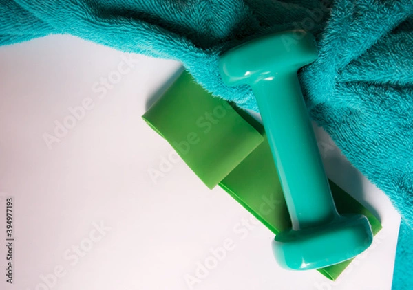 Obraz getting ready for summer sports. green dumbbells and fitness gum