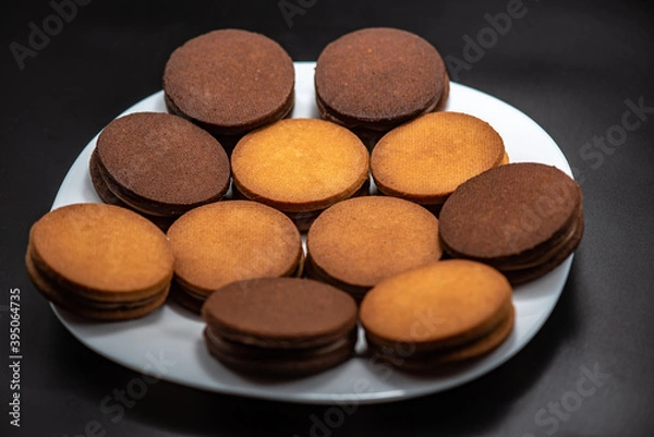 Obraz Round roast with chocolate in confectionery on a black background