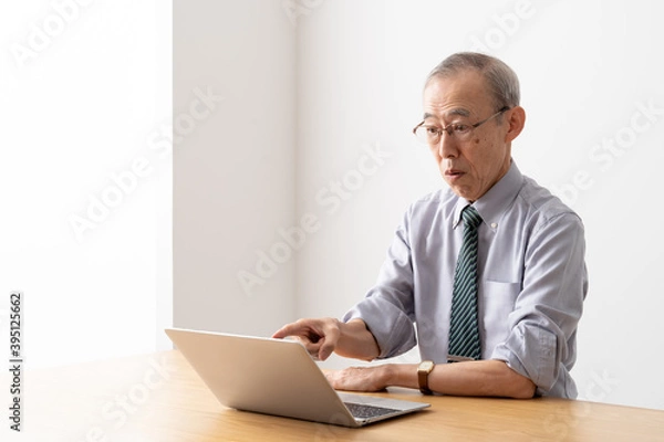 Fototapeta パソコンでオンライン会議をするシニアビジネスマン