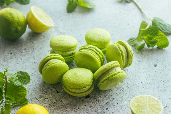 Obraz Macaroons. Green macaroons with lime and mint leaves. Delicious french desserts. Macaroons on the table
