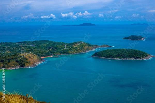 Fototapeta Natural background of seaside scenery (with coconut trees, boulders, sandy beach) and blurred sea waves.