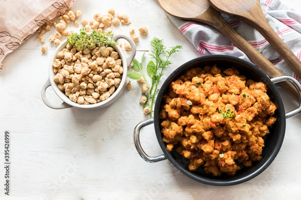 Obraz A great bolognese soya meat casserole next to a little white raw soya meta one on a white wooden background.