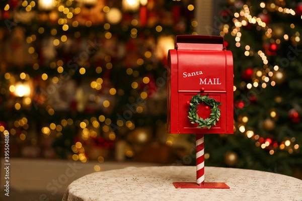 Fototapeta red mailbox for letters to santa claus on the background of a glowing christmas tree