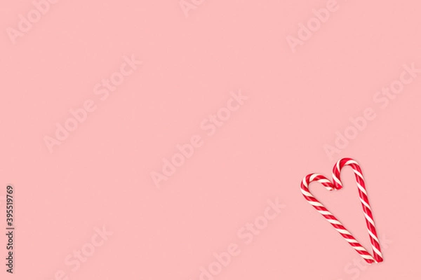 Obraz Christmas composition made of candy cane laid out in the shape of heart on a pink pastel background. Background made of food. Valentine's day and Christmas concept. Flat lay. Minimal composition