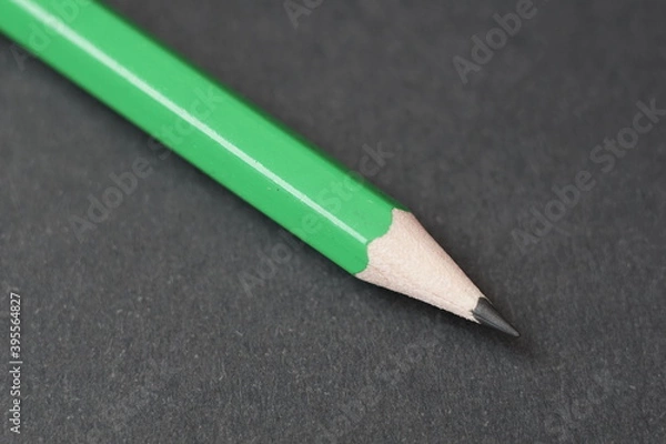 Obraz green pencil on a black background