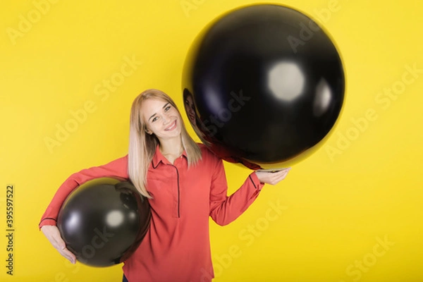 Obraz girl posing with two giant balloons on a yellow background
