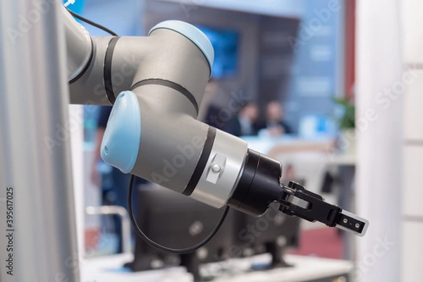 Fototapeta Close up view of moving futuristic robotic clamp arm at robot exhibition. Future, engineering, cybernetic, science and robotic concept