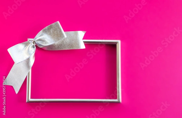 Obraz Bright holiday background. Empty frame and bow on pink background. Concept greetings for Christmas, thanksgiving, New year, mother's Day, birthday, Valentine's Day. Flat lay, copy space